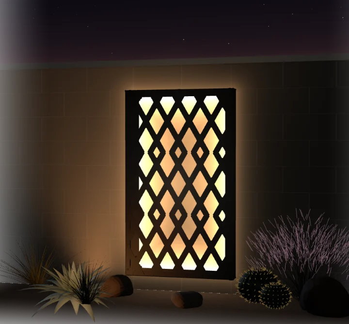 The finished frame lit from within on a 6 ft block wall at night, warm light washing the wall behind the diamond pattern, desert planting at its foot and stars above the wall cap.