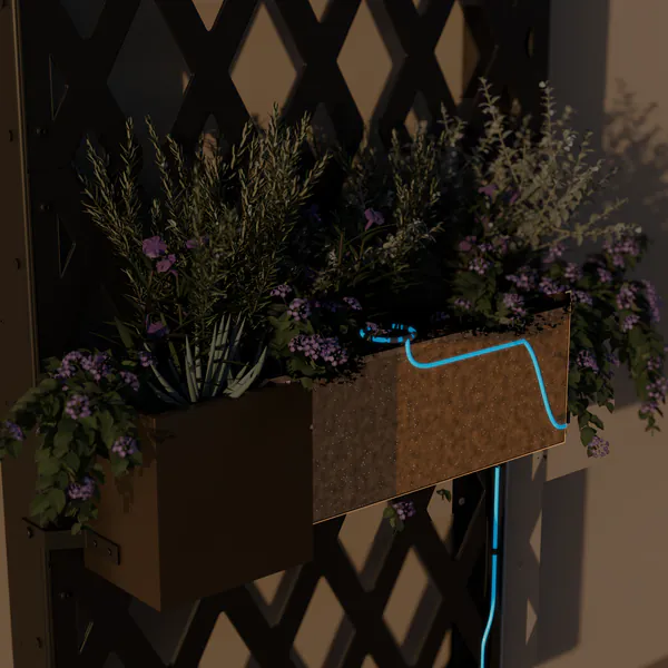 Cutaway of the same planter: the drip line rises inside the frame's right side wall, held in clips, then runs under the soil to a drip ring around the plants in the middle of the planter